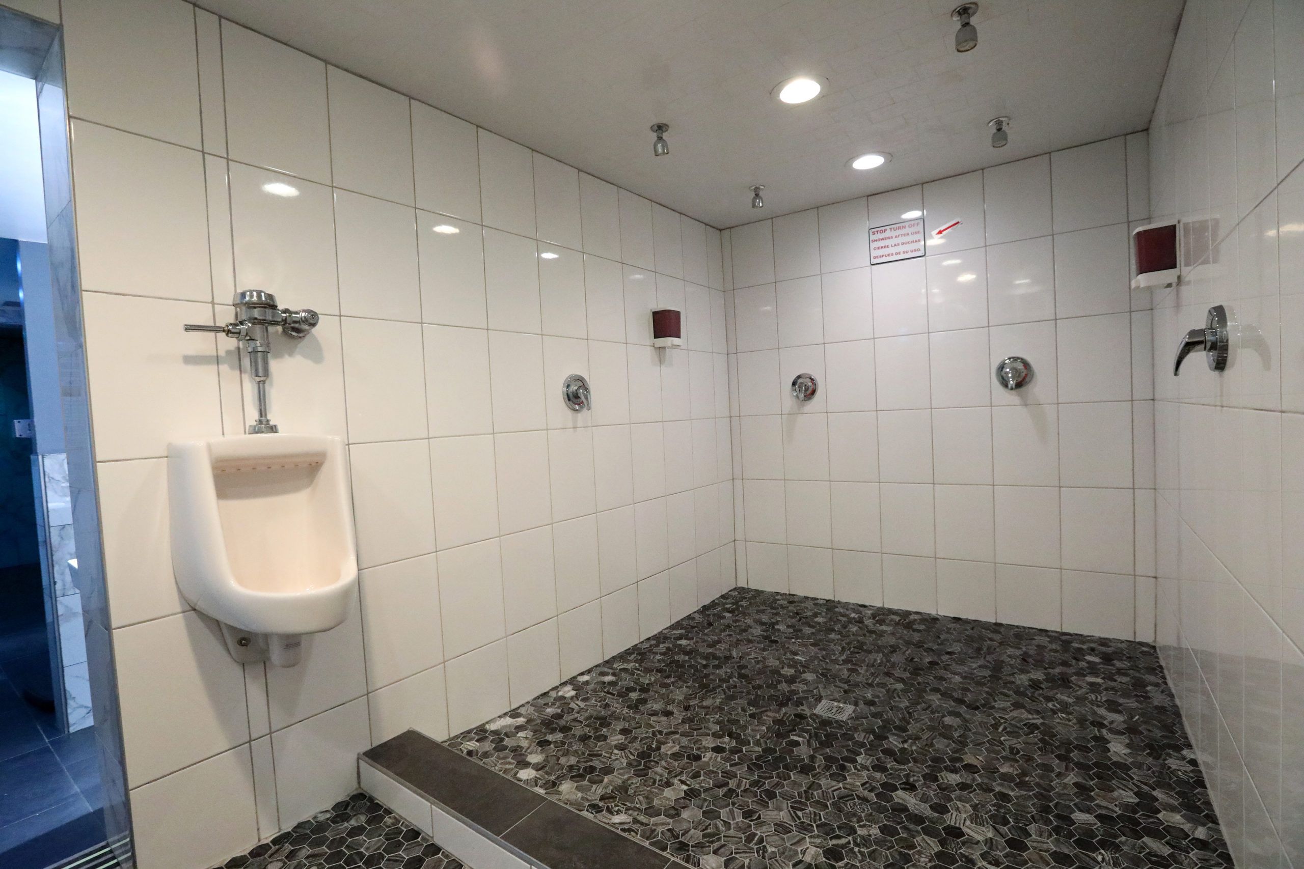 Open tiled shower room with several shower heads